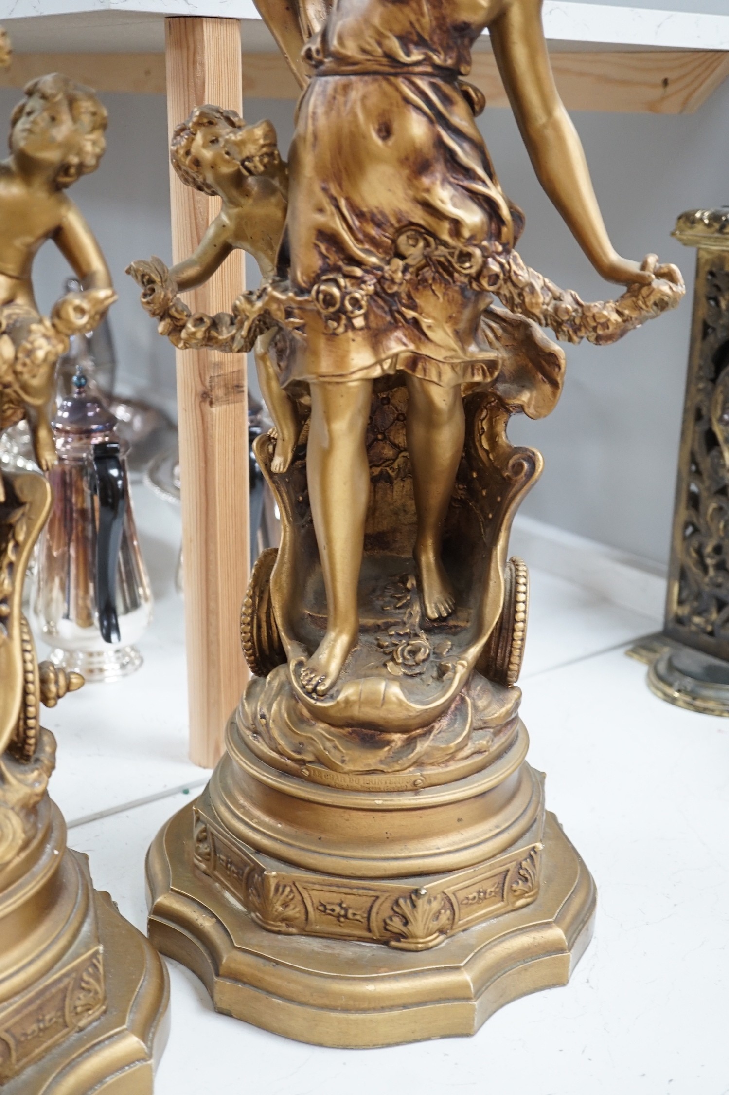 A pair of gilt spelter groups of a classical maiden and cherub, 61cm tall